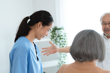 Asian nurse support senior elderly male, Asian older aged man doing physiotherapist in home living room using walker workout exercise for patient with caregiver in health insurance nursing care