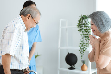 Asian nurse support senior elderly male, Asian older aged man doing physiotherapist in home living room using walker workout exercise for patient with caregiver in health insurance nursing care