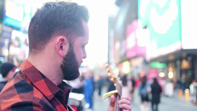 Musician is singing and playing on his guitar in New york city.