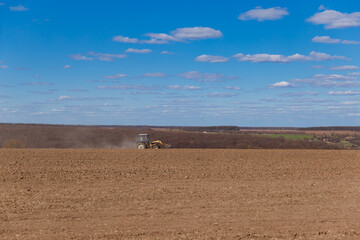 tractor plows the field, field in spring, tractor on the field

