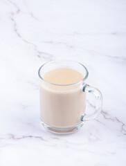 Masala tea in a glass mug with a handle.