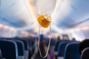oxygen mask drop from the ceiling compartment on airplane.. - obrazy, fototapety, plakaty