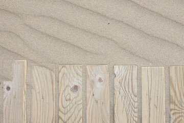 wooden boards on beach sand 