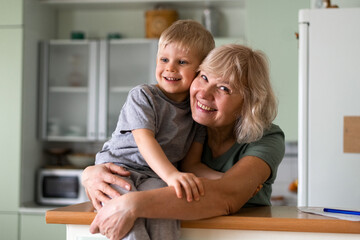 Happy family - grand mother hugs with grandson at home