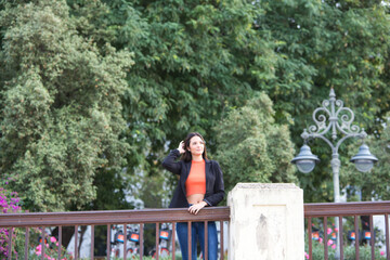 Fototapeta premium pretty young Spanish woman looking over the railing to the horizon. The woman is happy and content because she looks to the future with interest.