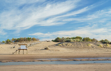 Summer, lifeguard shelter on a beach. Blue sky with some clouds and dunes. Copy Space