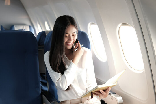 woman talking with smartphone in airplane in flight time.