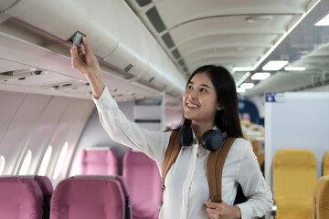Backpacker woman on the plane as she arrives and collects her luggage.