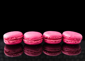 Pink macaroons on a black background. Place for text.