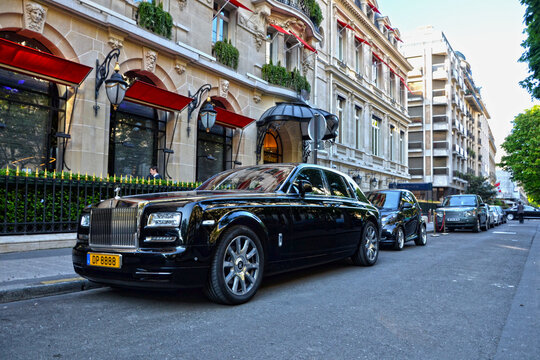 Paris, France - April 18th 2015: A black Rolls-Royce Phantom parked in front of the luxury Hotel Prince de Galles, showcasing elegance, prestige and high-end automotive design in daylight.