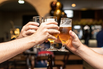 Amigos brincando taça de cerveja em comemoração