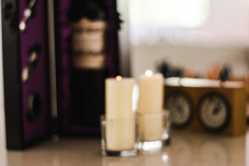 Lit cndles in glass containers out of focus