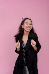 A young asian woman giddy with anticipation, excited for the results. Isolated on a light pink...