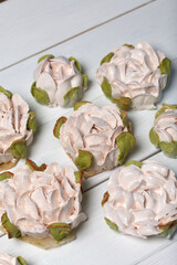 Zephyr flowers on white boards. Homemade marshmallow. Close-up.