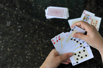 mãos jogando baralho, jogo de cartas sobre a mesa  - obrazy, fototapety, plakaty