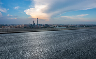 Asphalt road and modern city skyline at sunset. high angle view.