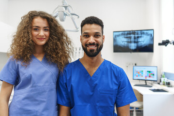 Portrait of young dentist and his nurse at private dental clinic.