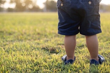 Closeup of little boy's walking  on playground outdoors,football field .The beginning of the exercise of the children.