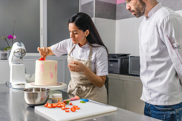 Colombian Pastry Chef. Chef begins to decorate the cake under the supervision of his superior.