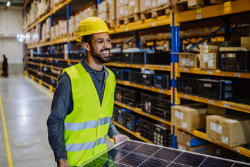 Portrait of warehouse worker carring solar panel.