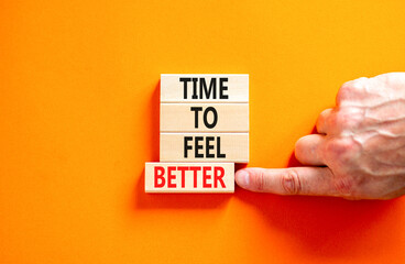 Time to feel better symbol. Concept words Time to feel better on wooden block. Beautiful orange table orange background. Businessman hand. Motivational business time to feel better concept. Copy space