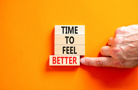 Time to feel better symbol. Concept words Time to feel better on wooden block. Beautiful orange table orange background. Businessman hand. Motivational business time to feel better concept. Copy space