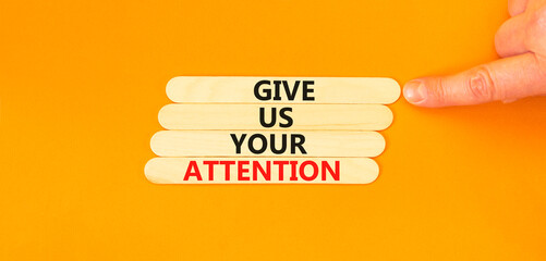 Give us your attention symbol. Concept words Give us your attention on wooden stick. Beautiful orange table orange background. Motivational business give us your attention concept. Copy space.