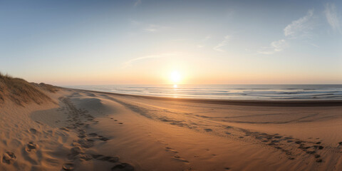 Fototapeta na wymiar Plage déserte à marée basse avec le soleil au ras de l'horizon, mer calme et ciel dégagé