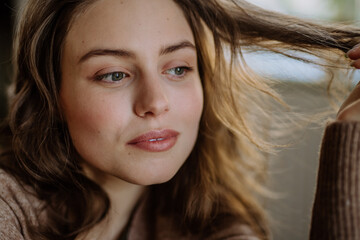 Portrait of young pensive woman, in her apartment.