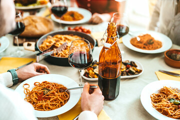 Group of friends having a pasta dinner party at restaurant - Happy young people eating italian traditional food together - Food and beverage lifestyle concept