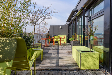 Rooftop terrace with green and terracotta furniture in Vienna