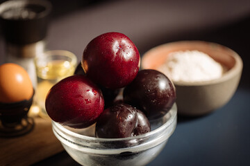 freshly washed  blue and purple plums in the bowl on the table 