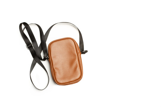  Bolso de mujer de color marr&oacute;n de cuero con asa negra larga sobre un fondo blanco liso y aislado. Vista superior y de cerca. Copy space