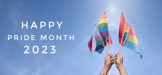 'Happy Pride Month 2023' on bluesky and rainbow flag raising background, concept for lgbt...