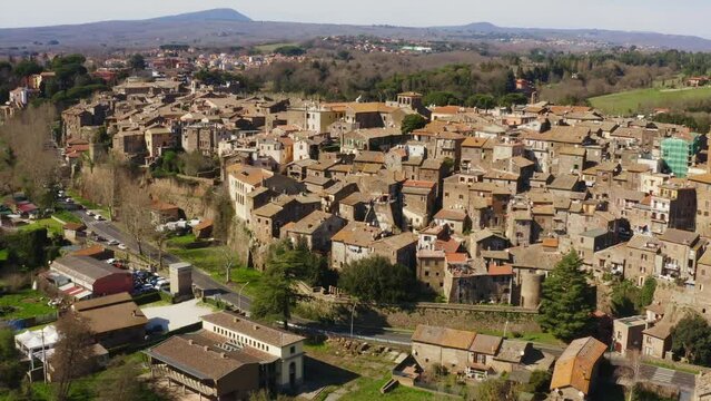 Aerial view of the historic center of Sutri, near Viterbo and Rome, Italy. The Romanesque cathedral with its bell tower dominates the city. All houses have traditional red tiled roofs in the old town.