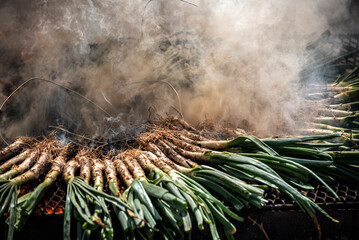 Preparación de grandes cantidades de calçots para una celebración festiva. Variedad de cebollas...