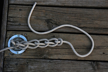 boat mooring rope with knots on a wooden dock