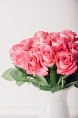 Beautiful bunch of fresh pink roses in full bloom against white background. Bouquet of flowers. Valentine's day or Mother's day card.