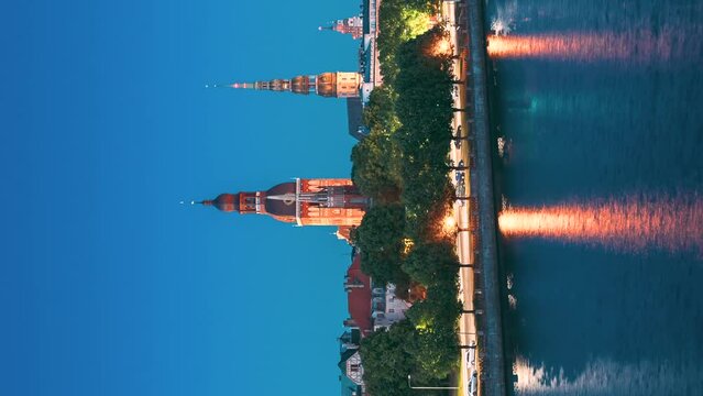 Riga, Latvia, Europe. Hyperlapse Cityscape Skyline In Evening Time. Night View Of Castle, Dome Cathedral And St. Peter's Church. Vertical Footage Video Popular Place. Unesco World Heritage Site.