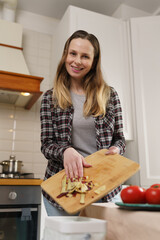 Cheerful white woman composting organic food waste at home. Portrait of friendly female person...