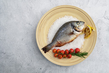 Top view of plate with fresh grilled dorado fish with lemon and tomato