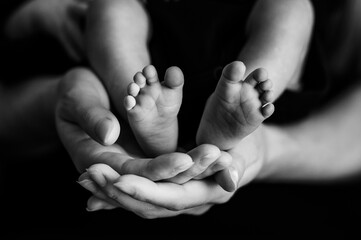 Parents holding their baby's feet. Parental love. Newborn.