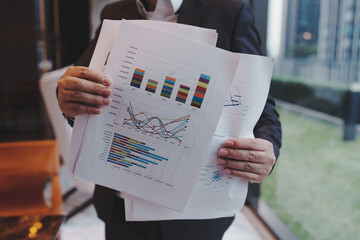 Close up of young business man and digital number of stock market background to represent...