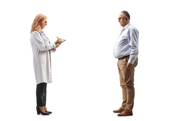 Fototapeta premium Full length profile shot of a female physician writing a document and standing with a mature man