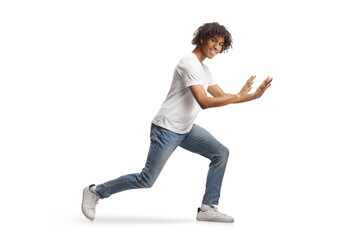 Young african american man standing and pushing something