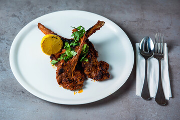 Grilled Lamb Chop with lemon slice and spoon served in dish isolated on grey background top view of bahrain food