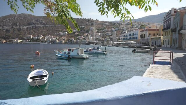 Small boats in bay and Symi Town, Symi Island, Dodecanese Islands, Greek Islands, Greece, Europe