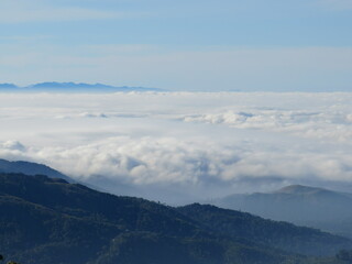 Fototapeta na wymiar Enveloped in Majesty: The Serenity of Clouds Draping Over Majestic Mountains