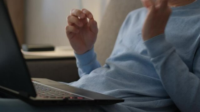 Unrecognizable deaf mute man communicating in sign language in video chat