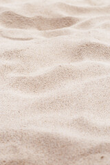 Fototapeta na wymiar Beige pink Sand texture natural background. Close up waves pattern on sand dunes, light color, minimal nature vertical backdrop. Summer and travel, spa concept. Selective focus.